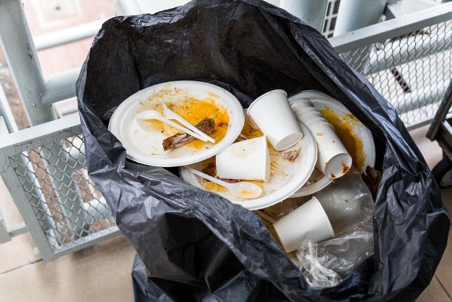 styrofoam plates and cups disposed in plastic garbage bag