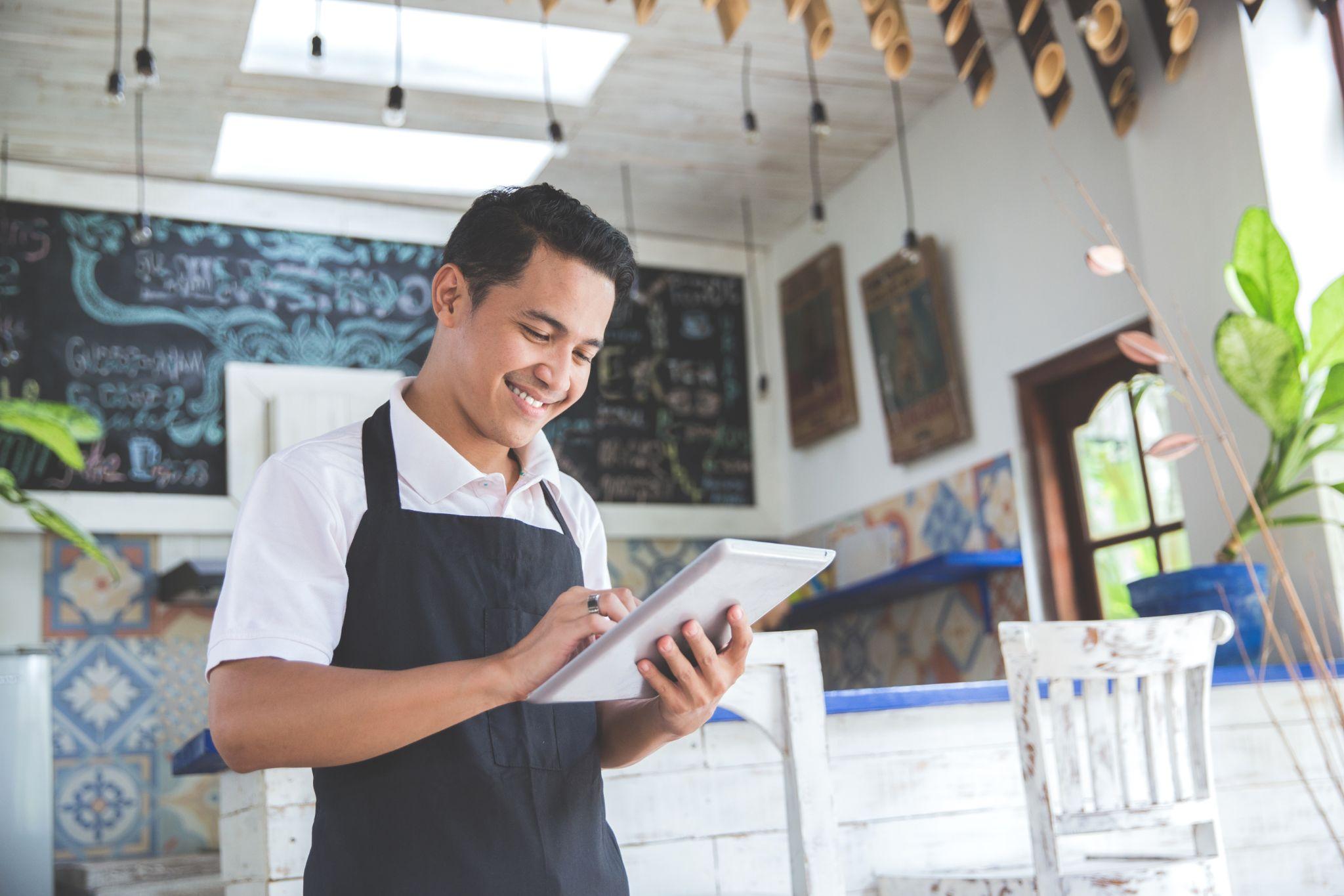 young male cafe owner with tablet