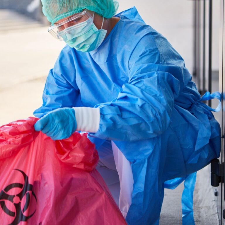 Cleaner checking the disposal of hazardous waste in the clinic