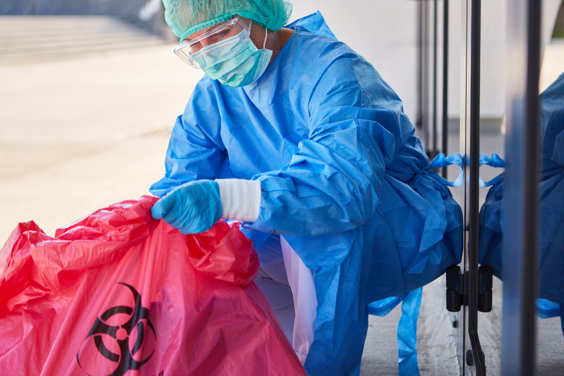 Cleaner checking the disposal of hazardous waste in the clinic