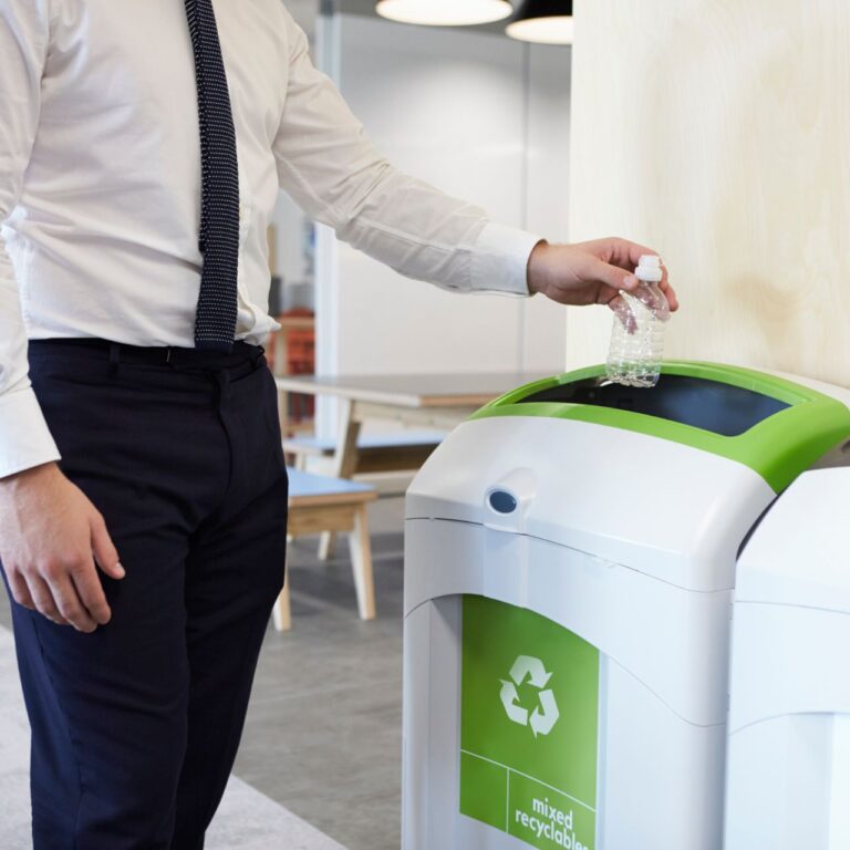 Man throwing plastic bottle into recycling bin