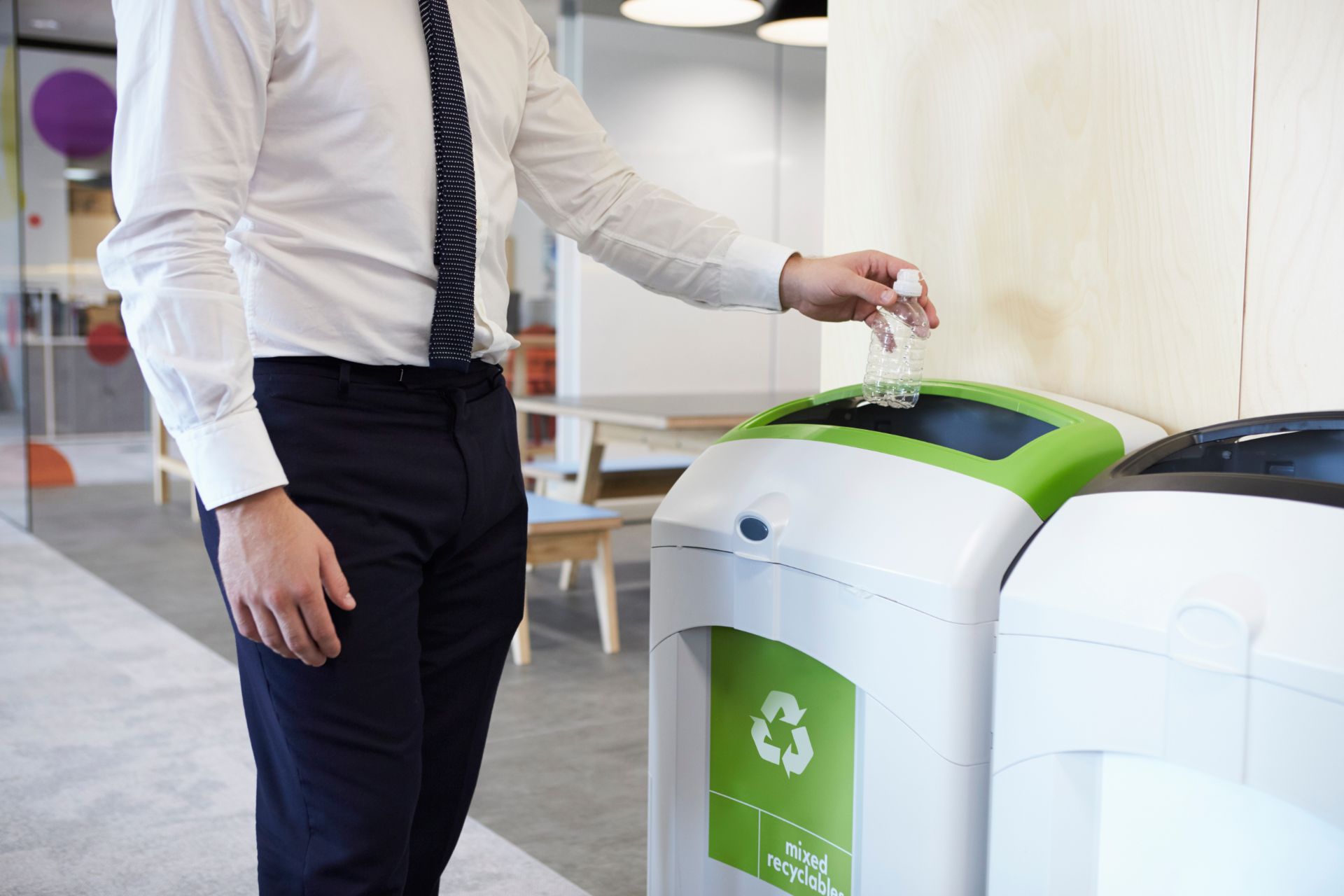 Man throwing plastic bottle into recycling bin