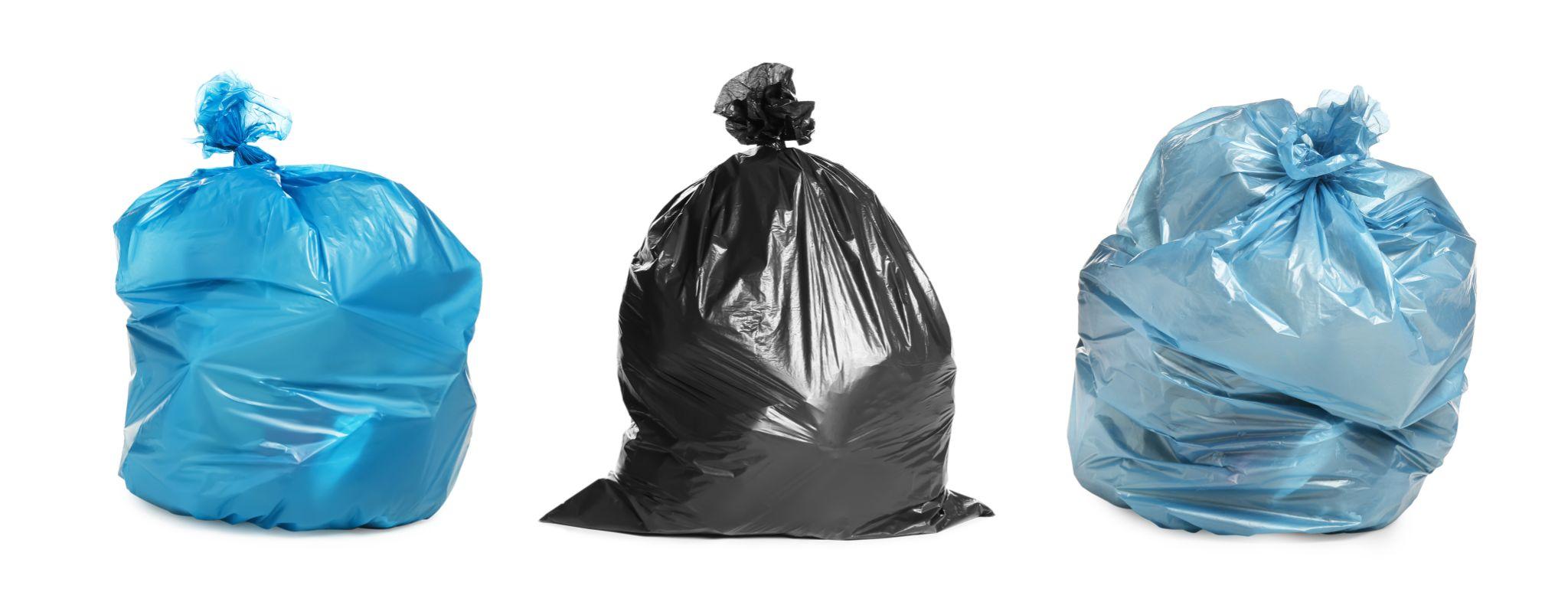 Set with trash bags filled with garbage on white background