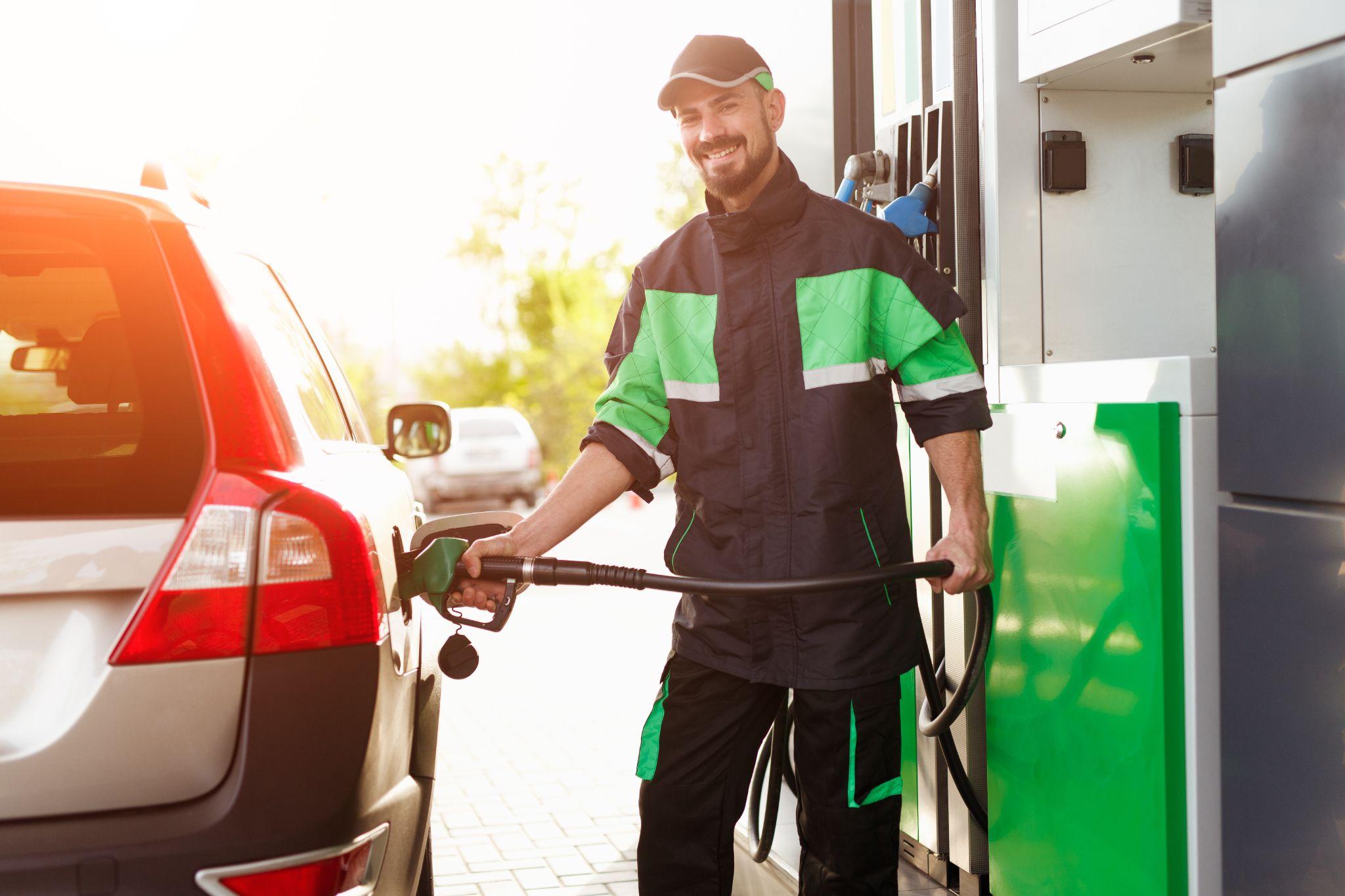 Gas station worker pumping gas