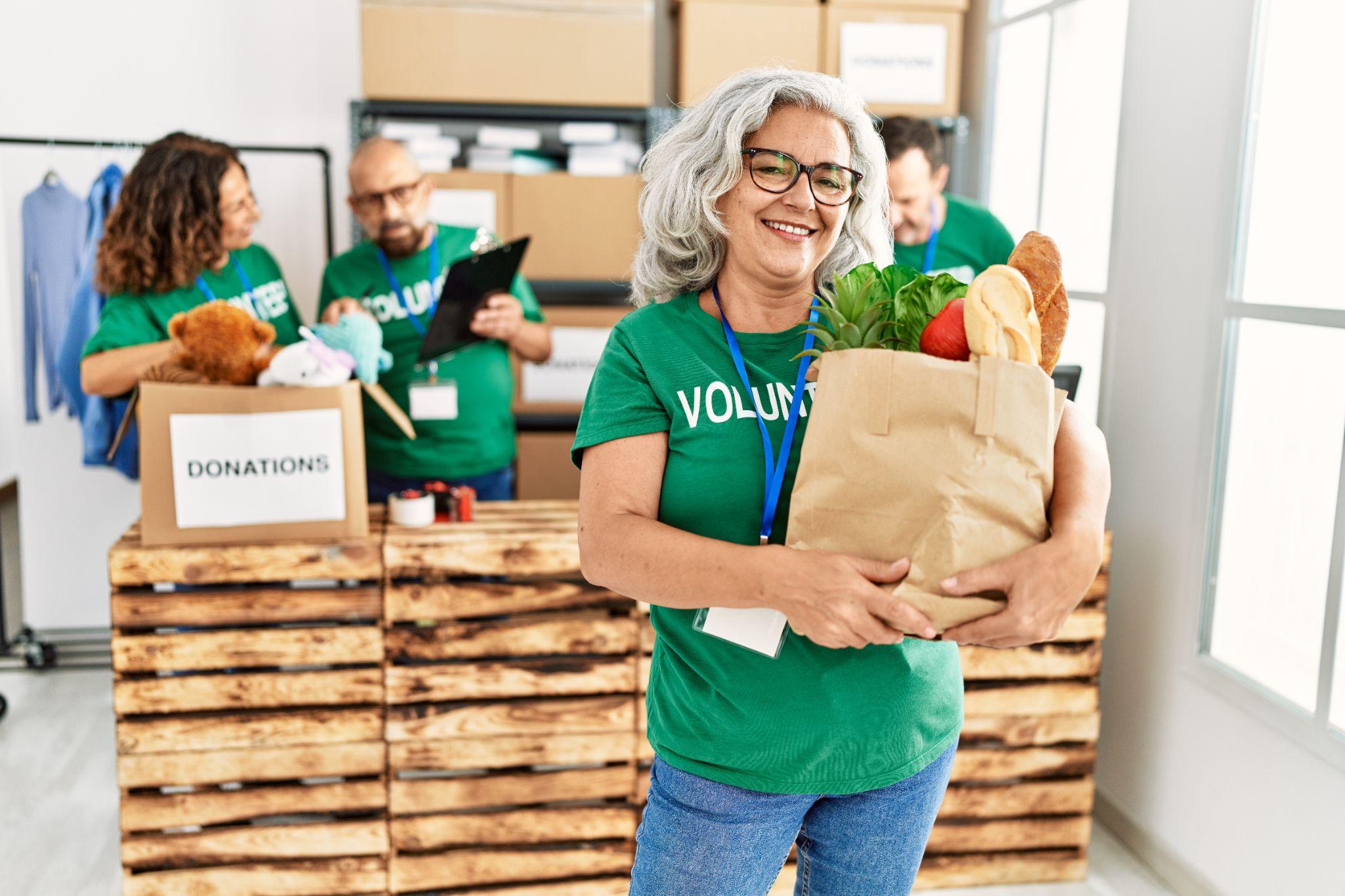 Smiling volunteer holding a bag of donated groceries