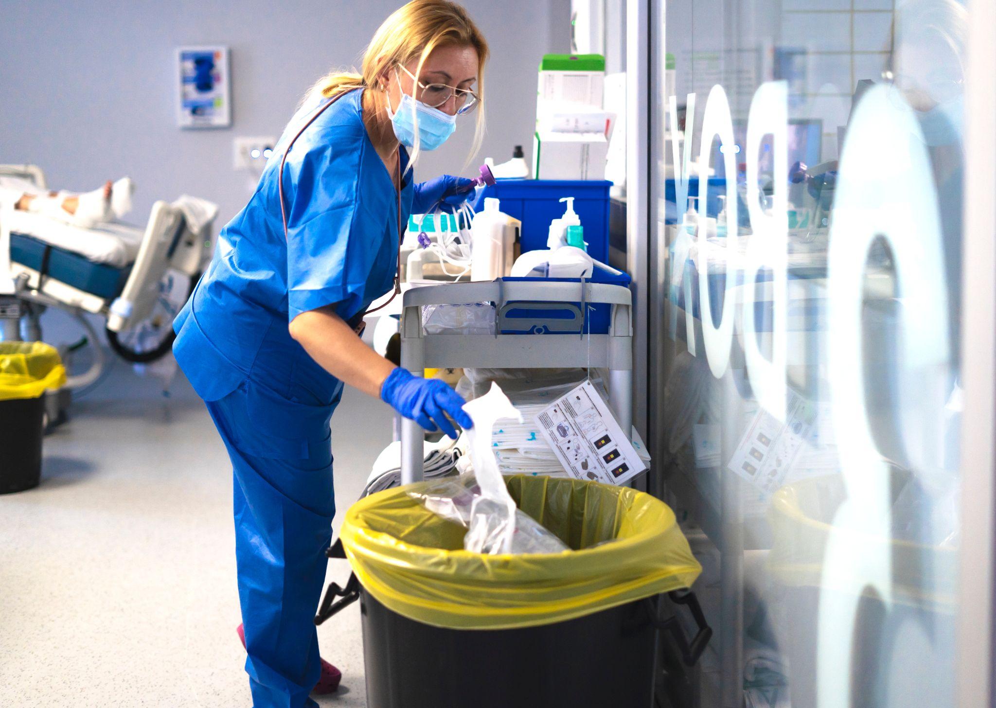 A nurse disposing of medical waste