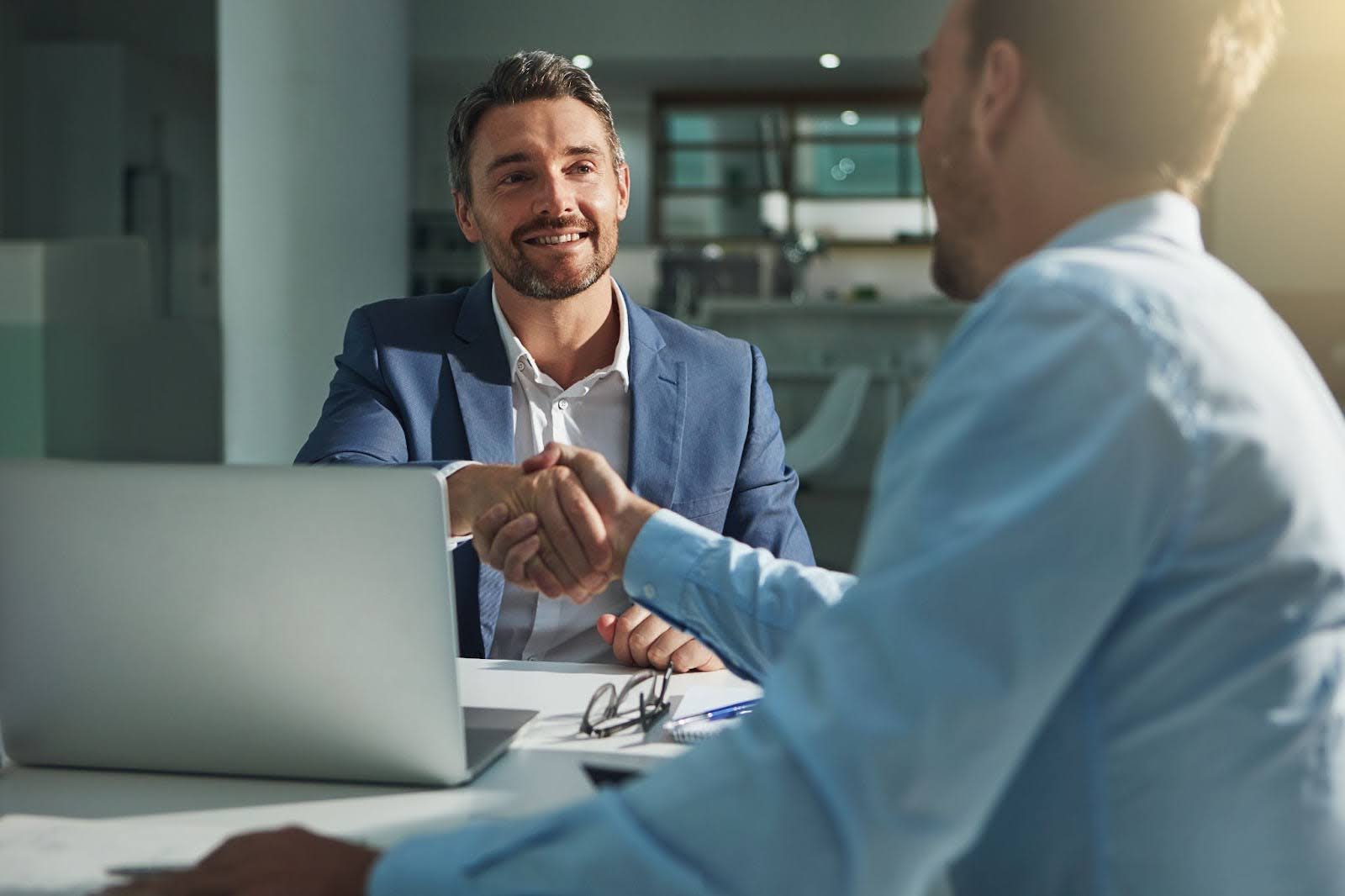 Business associates shaking hands over a desk